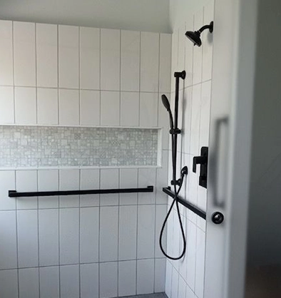 Modern Bathroom Shower with White Tiles and Black Fixtures