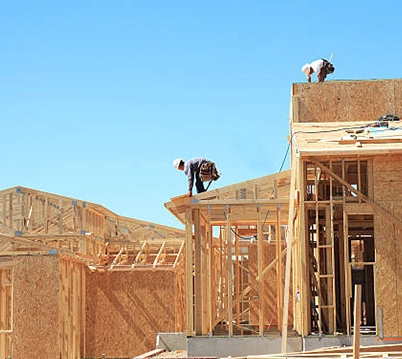 Construction Workers Framing a New Building Under Clear Blue Sky